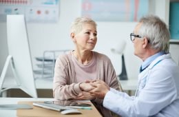 senior doctor giving hope and comfort to patient during voumed checkup