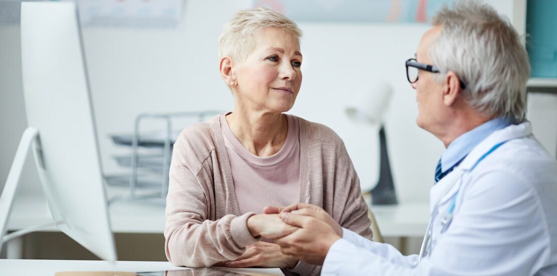 senior doctor giving hope and comfort to patient during voumed checkup